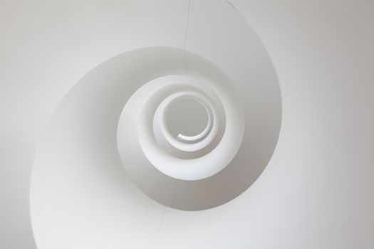 Abstract background image of a spiral shaped white staircase