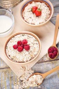 oat flakes with raspberry and strawberry in a bowl on textile