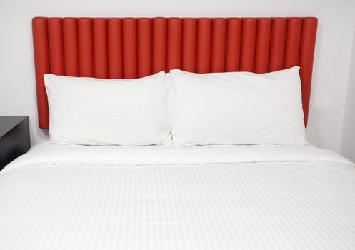 Bed with headboard and pillows in a hotel room