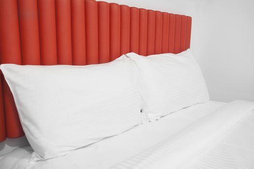 Bed with headboard and pillows in a hotel room