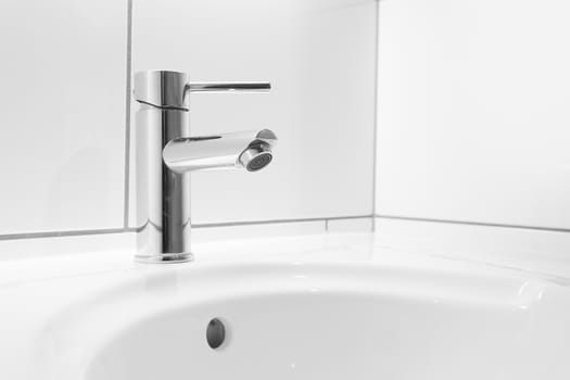 Faucet and white basin in a hotel bathroom