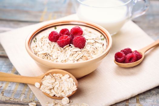 oat flakes with raspberry in a bowl on textile