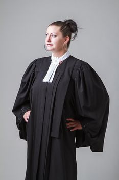 woman in her thirties, wearing a black toga canadian lawyer toga, looking to the left