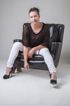 thirty year old woman sitting sensually on a sofa