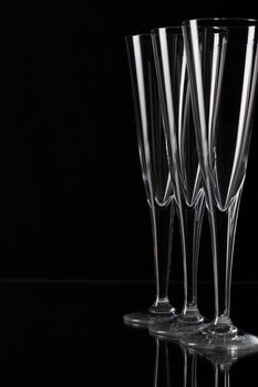 Three empty champagne glasses on a glass plate