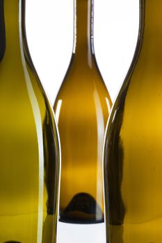 Detail of three empty wine bottles on a white background