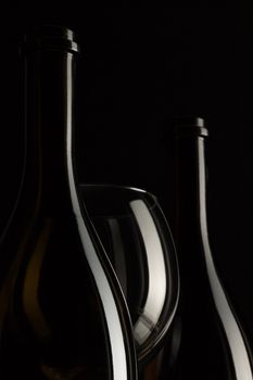 Silhouettes of elegant wine glasses and a wine bottles on a black background
