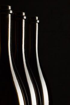 Silhouettes of elegant wine bottles on a black background