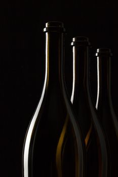 Silhouettes of elegant wine bottles on a black background