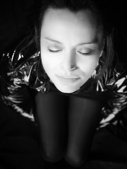 Black and white portrait of pretty woman with closed eyes in black leather coat