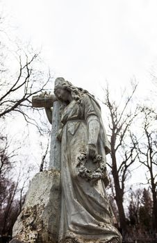 Old cemetery marble sculpture of the woman with cross