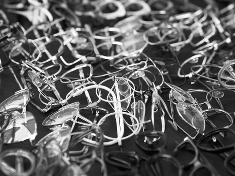 Black and white image of eyeglasses and eyeglasses rims pile