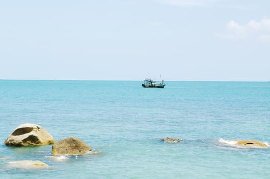 Tropical marine landscape with stones and ship on horizon. Koh Samui, Thailand.