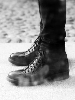 Close up of black and white image of black leather shoes