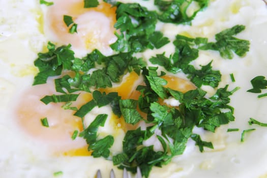 Fried eggs on the plate with a fork