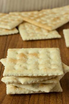 Saltine Crackers on a wooden table top or counter.