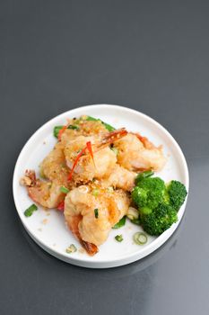 Thai style honey shrimp dish presented beautifully on a round white plate with copy space above.