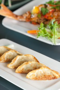 Fried thai gyoza dumpling appetizers with soy dipping sauce.