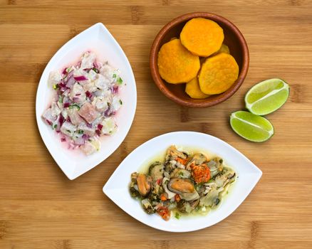 Overhead shot of fish and shellfish ceviche (raw fish and shellfish with red onion marinated in lime juice with garlic, salt and coriander) on wooden board, photographed with natural light