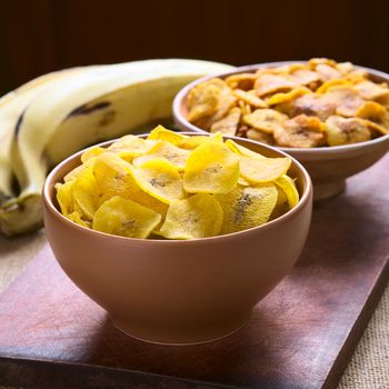 Bowls of salty (front) and sweet (back) plantain chips, a popular snack in South America photographed with natural light (Selective Focus, Focus on the upper chips) 