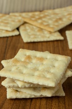 Saltine Crackers on a wooden table top or counter.