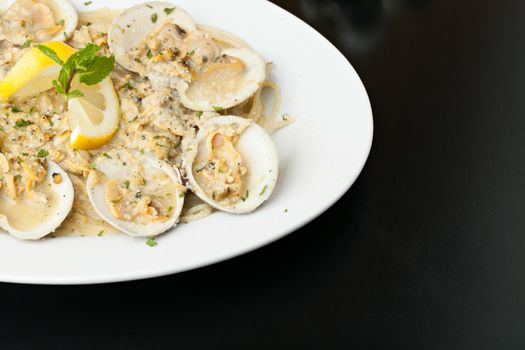 Italian pasta dish with fresh clams over pasta with copy space.