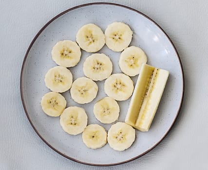 Delicious sliced banana in a dish over white leather background