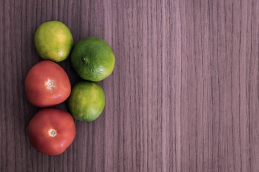 Three lemons and two tomatos on wood table 