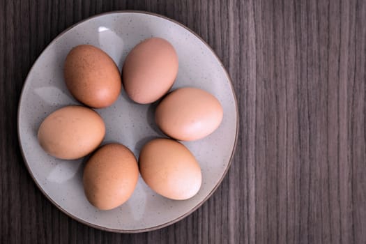 Six raw eggs arranged in a round dish 