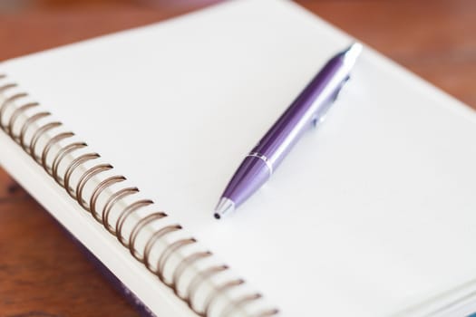 Blank notebook with pen on wooden table, stock photo