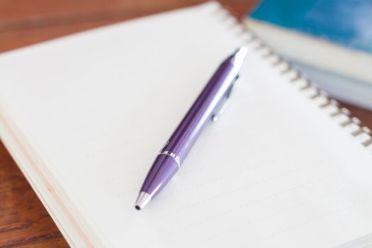 Blank notebook with pen on wooden table, stock photo