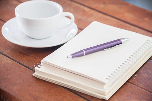 Blank notebook with pen on wooden table, stock photo