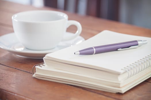 Blank notebook with pen on wooden table, stock photo