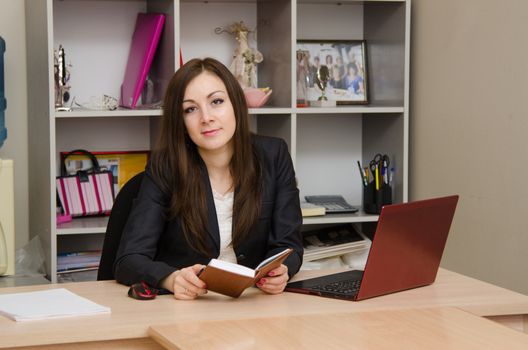 Cute business woman in the office at the computer
