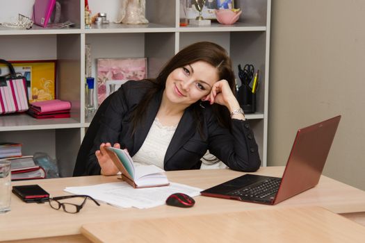 Cute business woman in the office at the computer