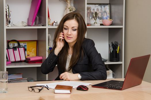 Cute business woman in the office at the computer