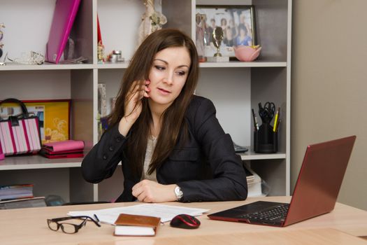 Cute business woman in the office at the computer