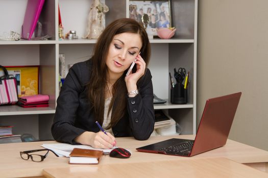 Cute business woman in the office at the computer