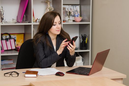 Cute business woman in the office at the computer