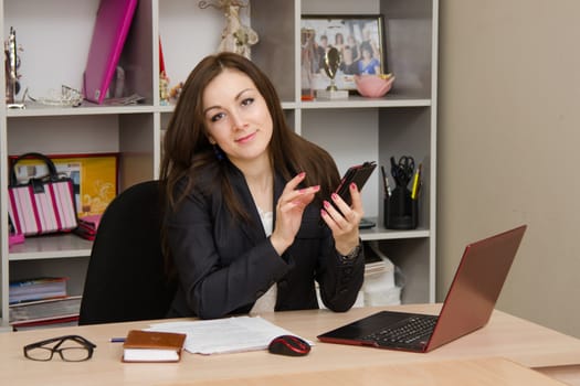 Cute business woman in the office at the computer