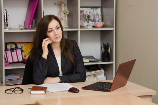 Cute business woman in the office at the computer