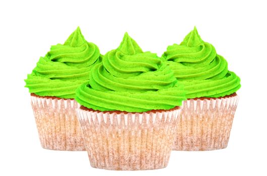 Three cupcakes with bright green frosting for St Patricks Day, isolated on a white background