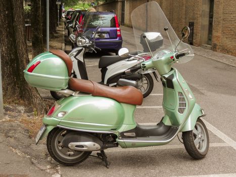 TREVISO, ITALY - CIRCA JULY 2014: green Vespa motorbike parked in a street