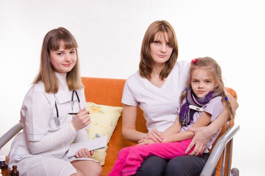 Doctor pediatrician examines a sick child at home in the presence of my mother