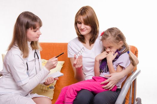 Doctor pediatrician examines a sick child at home in the presence of my mother