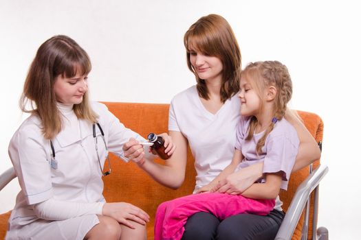 Doctor pediatrician examines a sick child at home in the presence of my mother