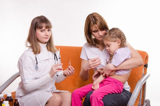 Doctor pediatrician examines a sick child at home in the presence of my mother