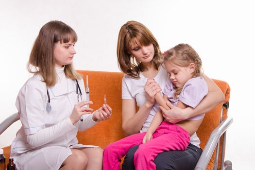 Doctor pediatrician examines a sick child at home in the presence of my mother