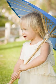 Playful Cute Baby Girl Holding Parasol Outside At The Park.