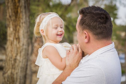 Affectionate Father Playing With Cute Baby Girl Outside at the Park.